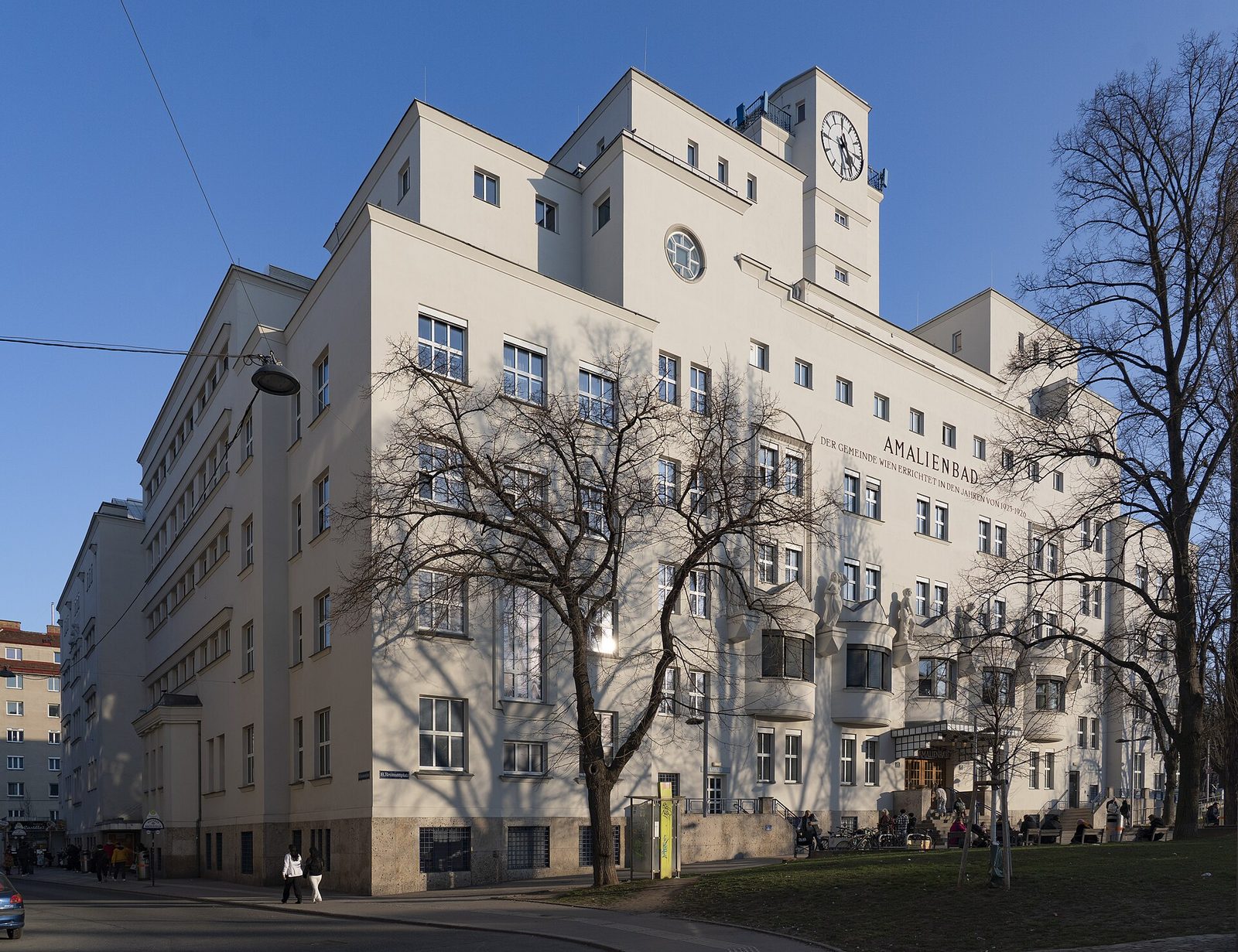 Fasada Amalienbad przy Reumannplatz w Wiedniu — modernistyczna bryła z wieżą zegarową i napisem budynku na elewacji